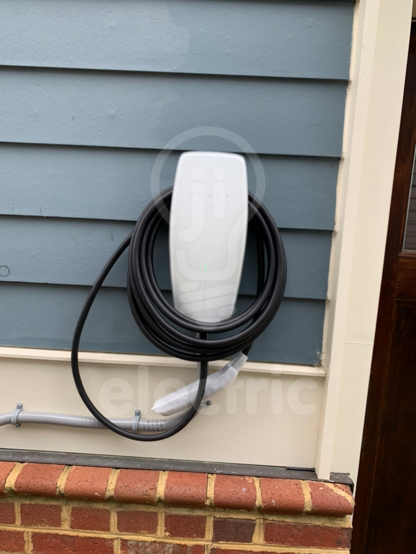 Tesla wall connector installed outdoor carport/garage.